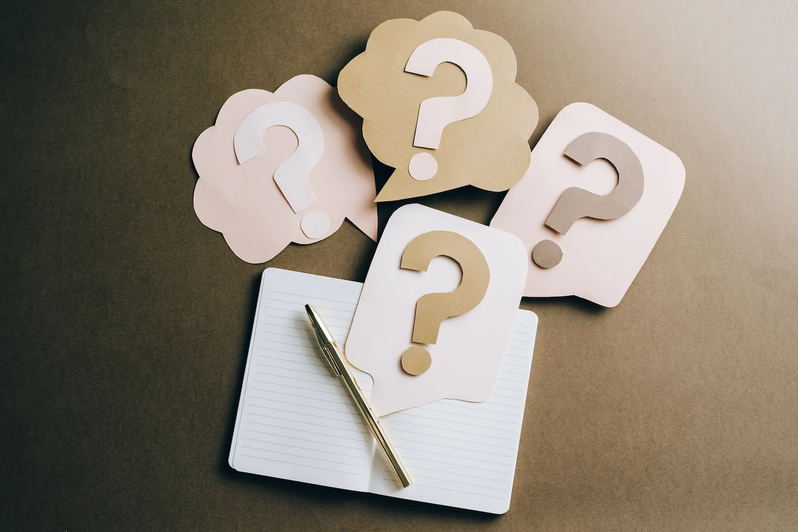 dba-faq-banner.webp Question-mark cards beside an open notebook and a pen.