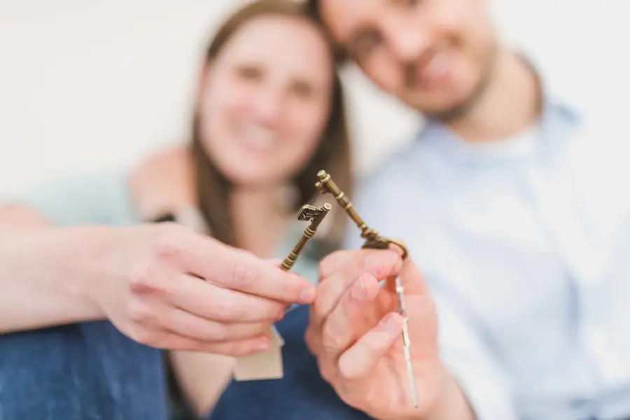 dba-acquisition-banner.webp Smiling couple holding house keys together.