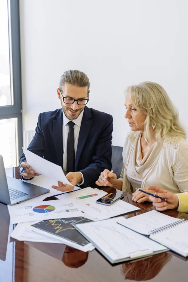 Two professionals reviewing financial charts and paperwork together.