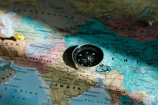 Compass resting on a world map.