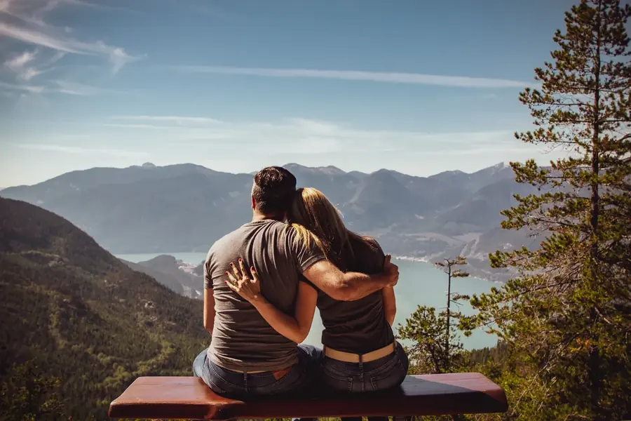 dba-value-banner.webp Couple sitting together overlooking a mountain landscape.