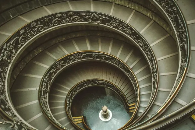 View down an ornate spiral staircase.