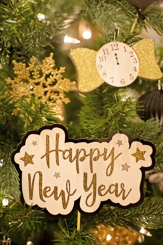 Happy New Year decoration beside a clock ornament and holiday lights.
